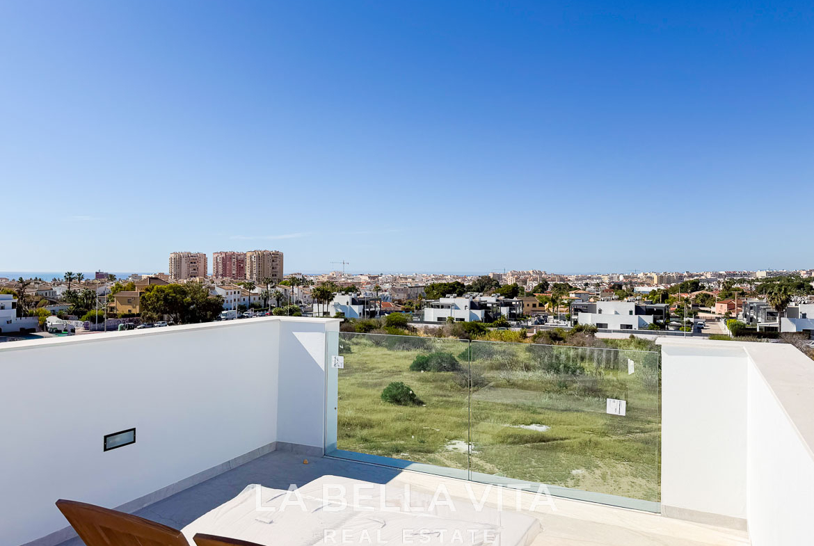 Sun-drenched terrace with glass railing and panoramic views in a modern new build villa in Aguas Nuevas, Torrevieja