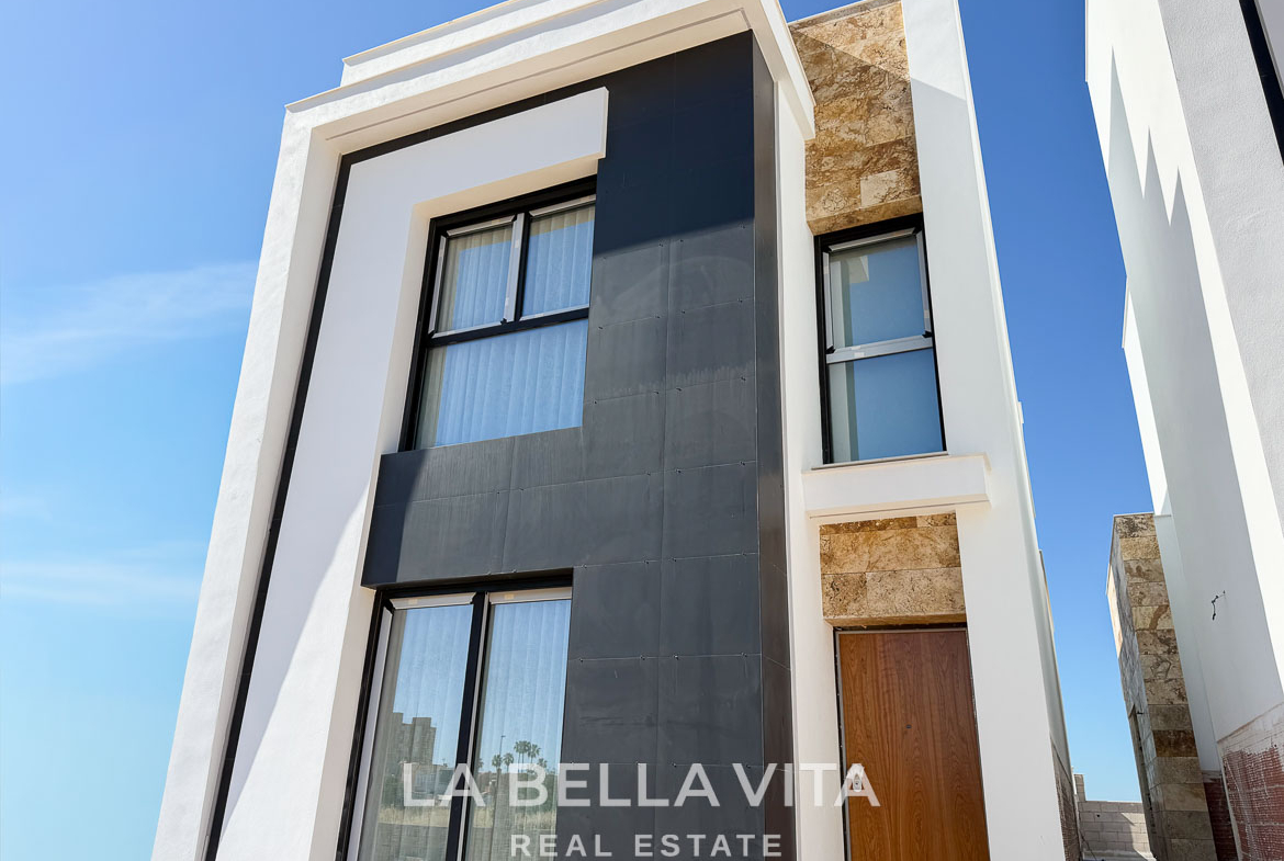 Modern new build villa exterior with sleek black and stone accents, bright and elegant in Aguas Nuevas, Torrevieja.