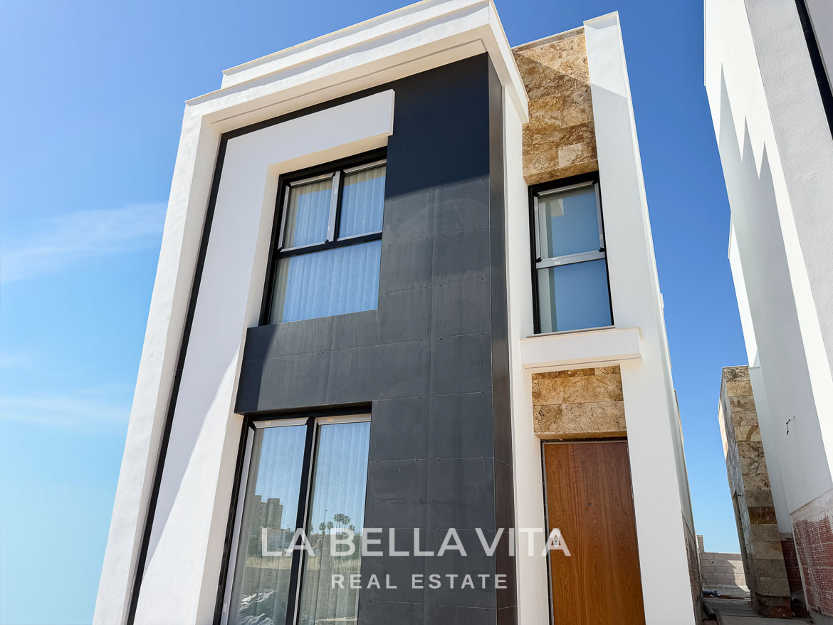 Modern new build villa exterior with sleek black and stone accents, bright and elegant in Aguas Nuevas, Torrevieja.