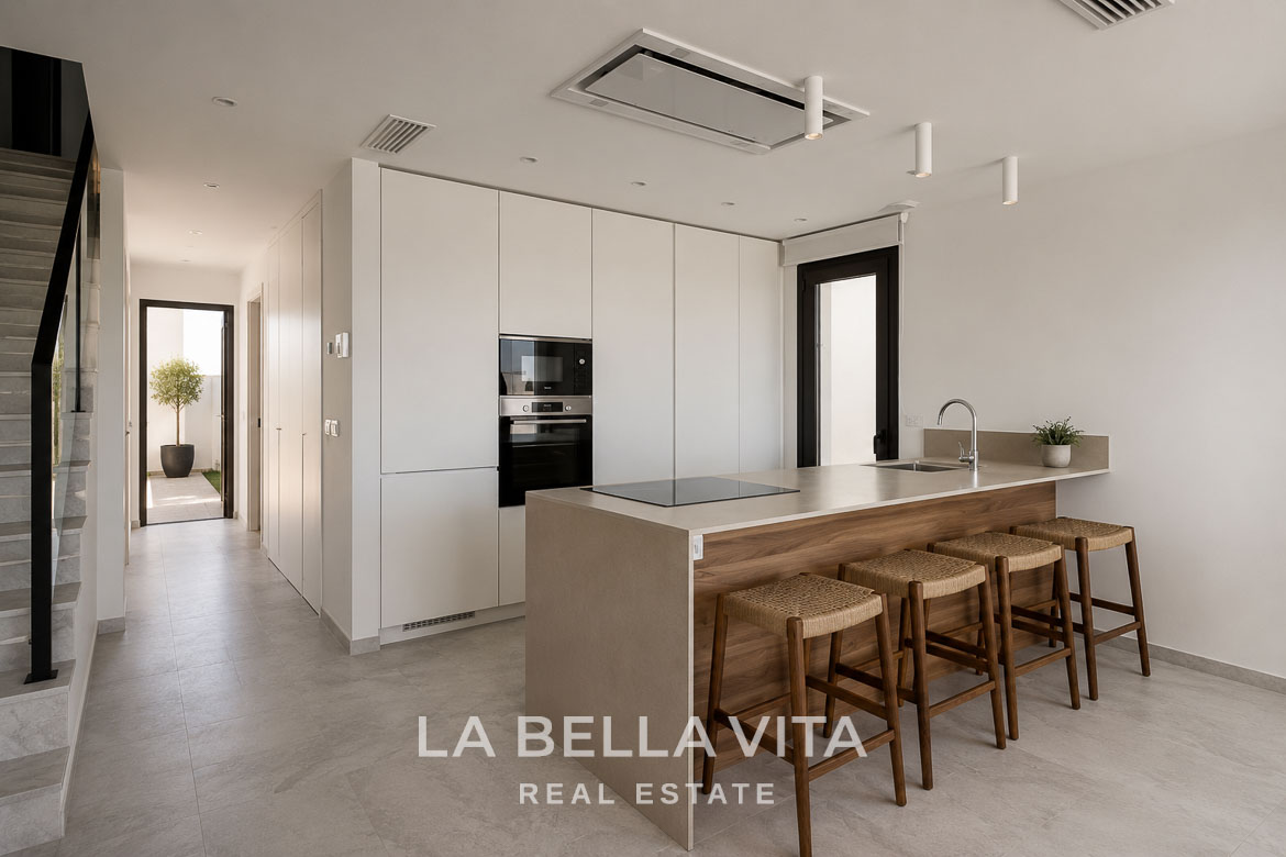 Modern open-plan kitchen with sleek cabinetry and breakfast bar in new build villas in Aguas Nuevas, Torrevieja