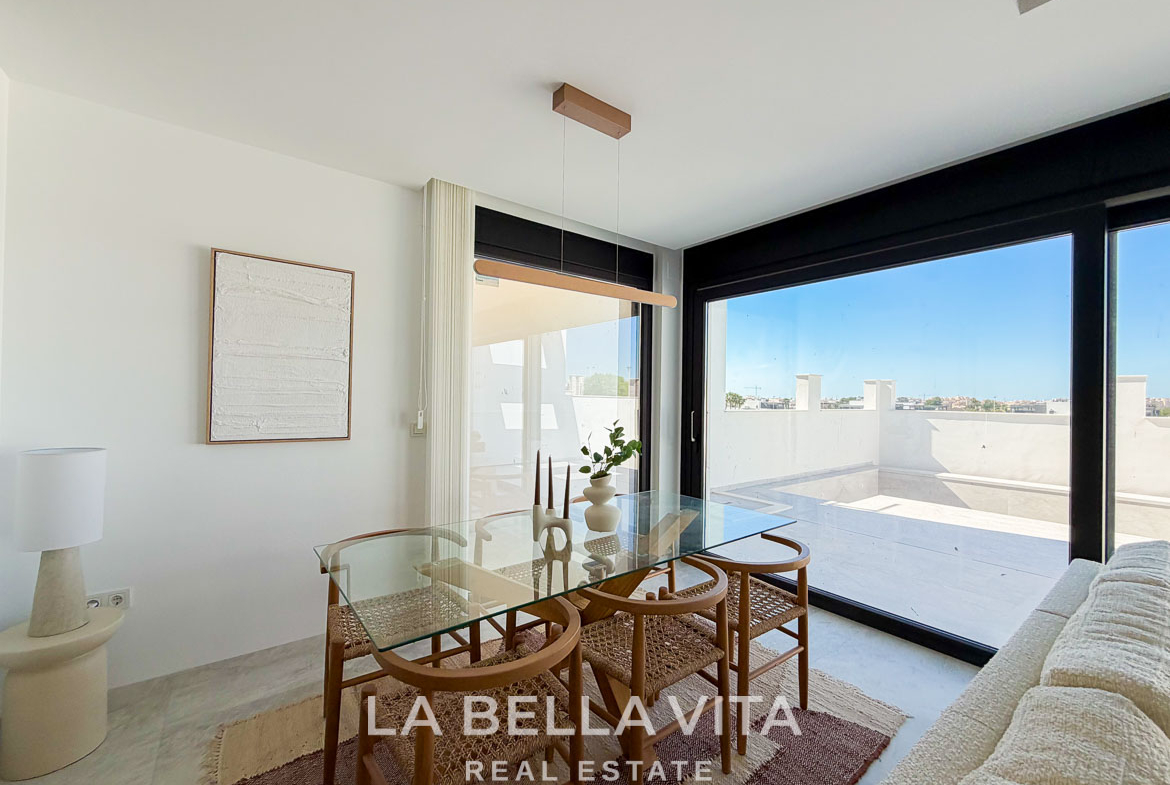 Bright, modern dining area with glass table and terrace in a new build villa for sale in Aguas Nuevas, Torrevieja