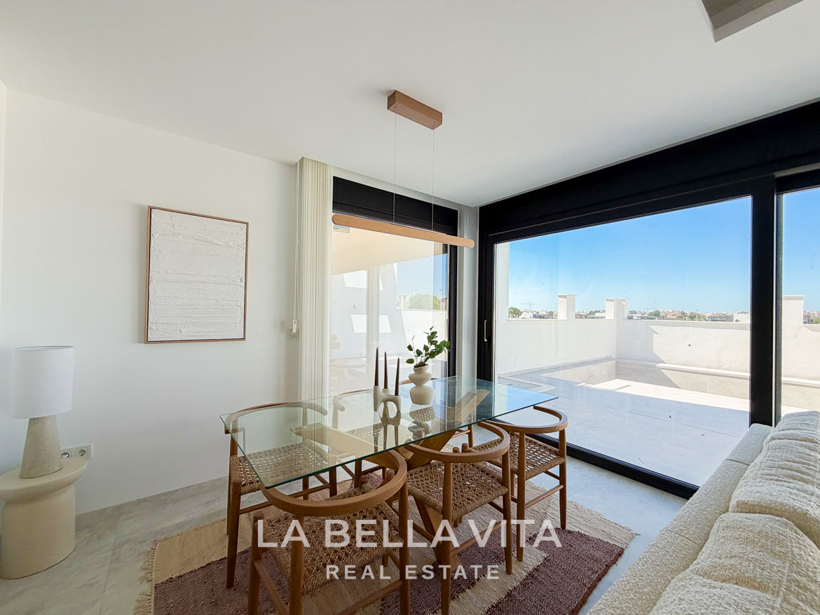 Bright, modern dining area with glass table and terrace in a new build villa for sale in Aguas Nuevas, Torrevieja