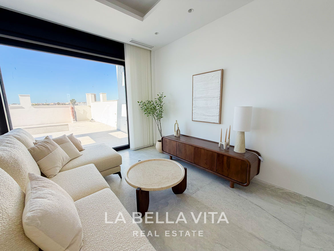 Bright, modern living room with plush sofa and sleek wooden console in new build villa with private pool in Aguas Nuevas, Torrevieja.