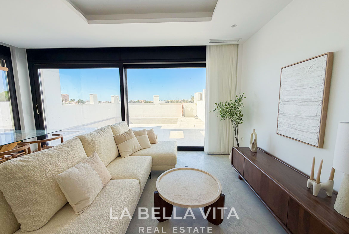 Bright, modern living room with plush sofa and large sliding glass doors in new build villa, Aguas Nuevas, Torrevieja.