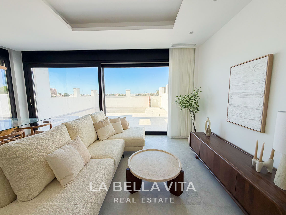 Bright, modern living room with plush sofa and large sliding glass doors in new build villa, Aguas Nuevas, Torrevieja.