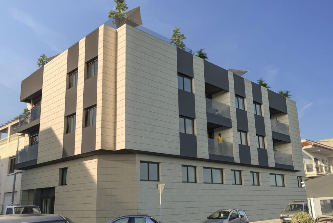 Corner façade of a modern apartment building with glass balustrades and rooftop planters