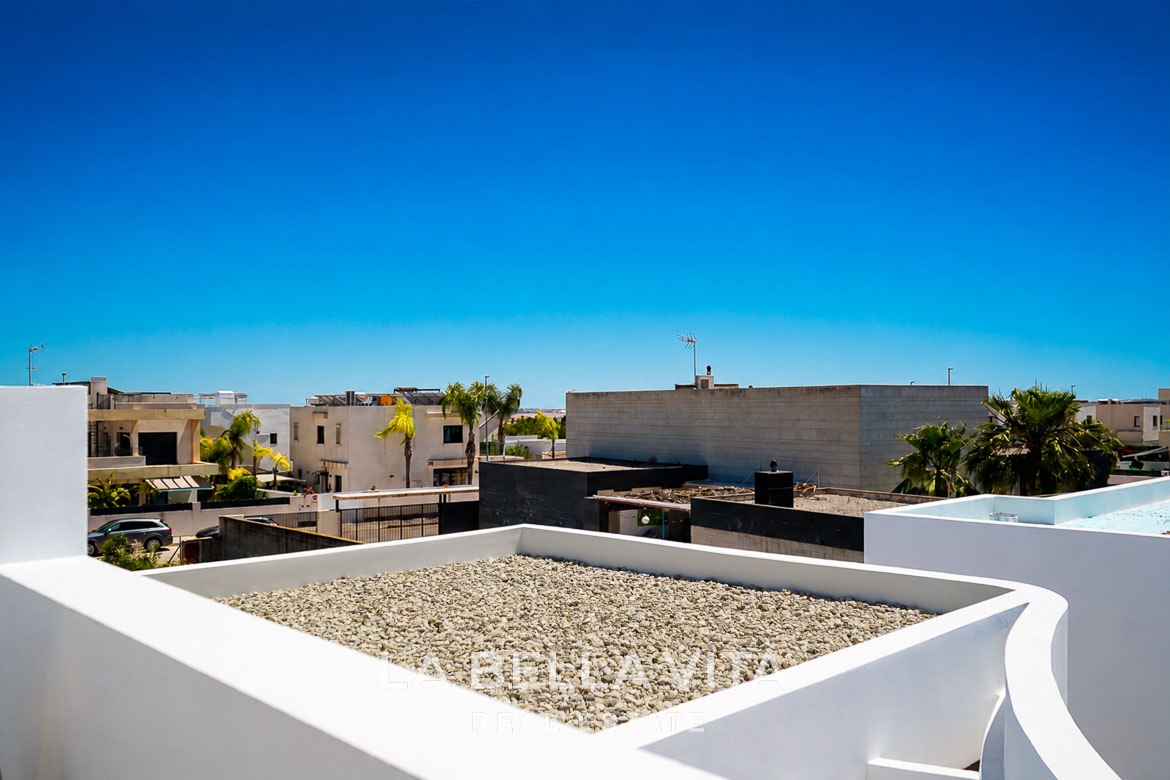 Bright, modern single-storey villa rooftop with sleek white walls and clear blue sky in Los Montesinos, Costa Blanca
