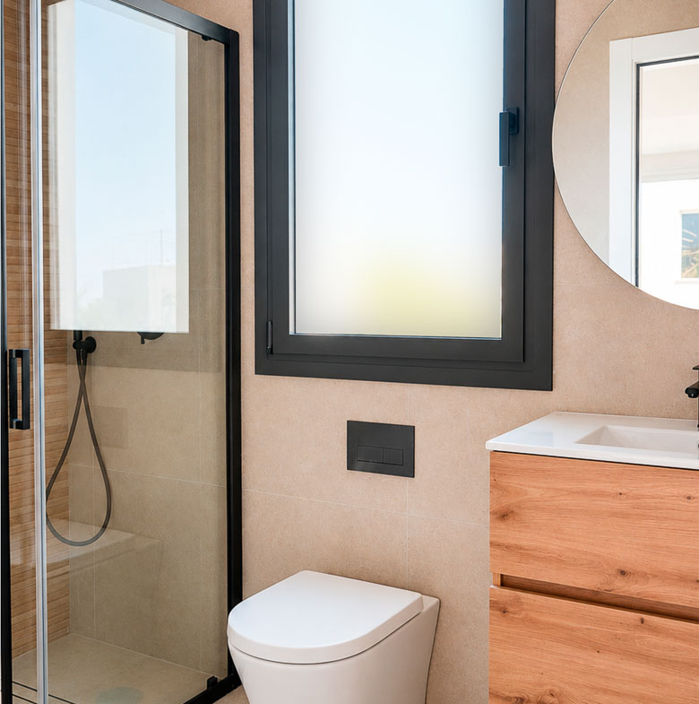 Modern, bright bathroom with sleek glass shower and wood vanity in key-ready single-storey villa in Los Montesinos, Costa Blanca