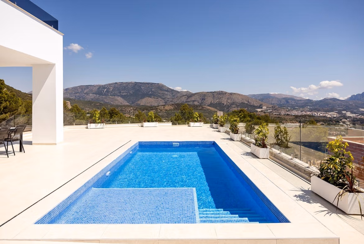 Stunning-New-Build-Villas-in-Polop-with-Sea-Views-4 Private pool and terrace of a new build villa in Polop with mountain and distant sea views under a clear sky.