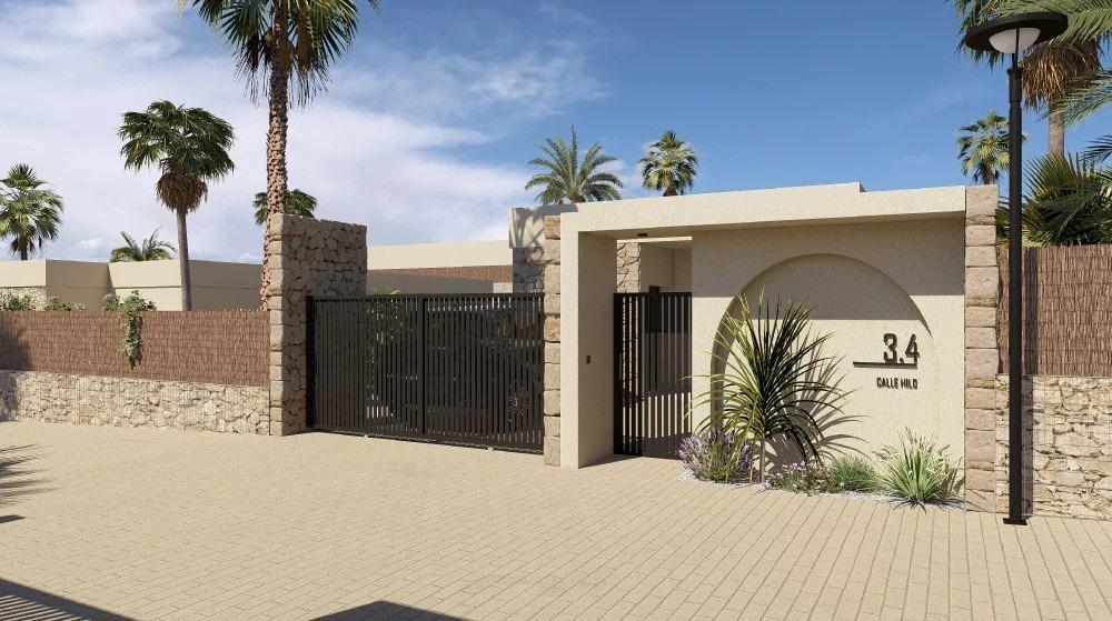 Exterior view of single-storey new build villa entrance with stone wall and gate in Altaona Golf Resort, Murcia.
