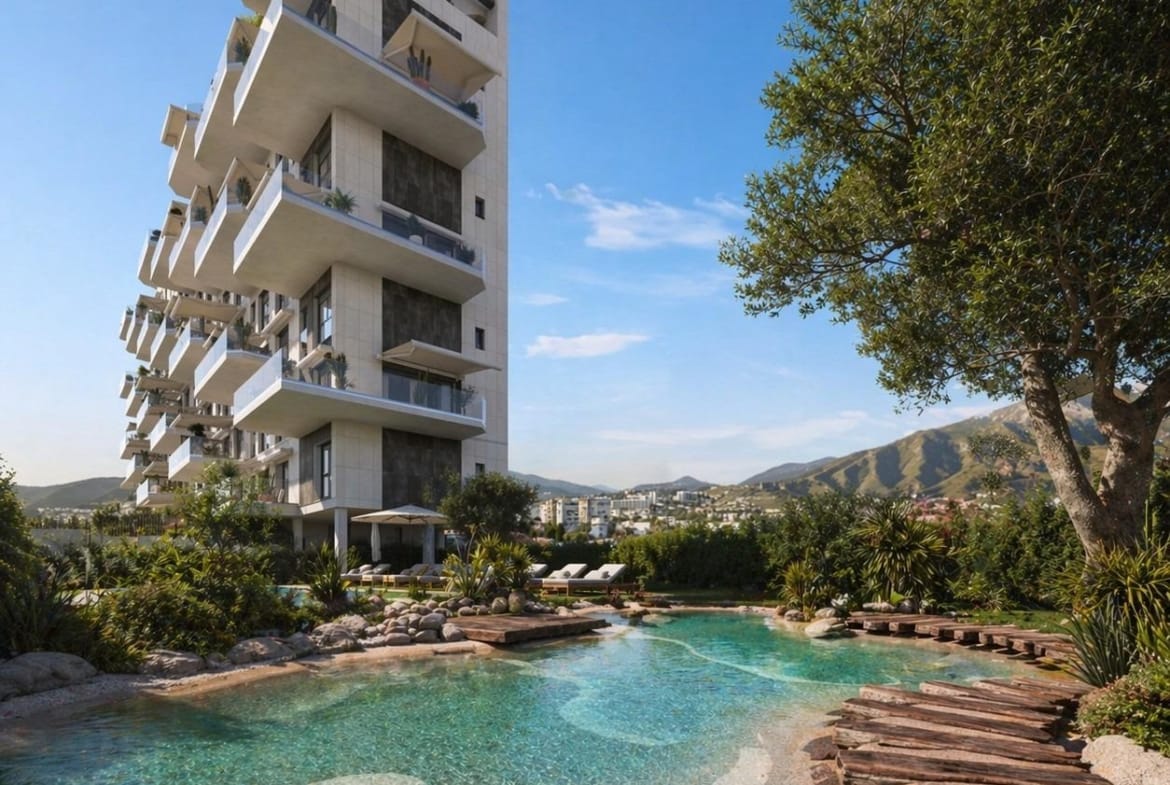 Modern elevated penthouse building with landscaped pathways and a natural-style pool in Cala de Finestrat.