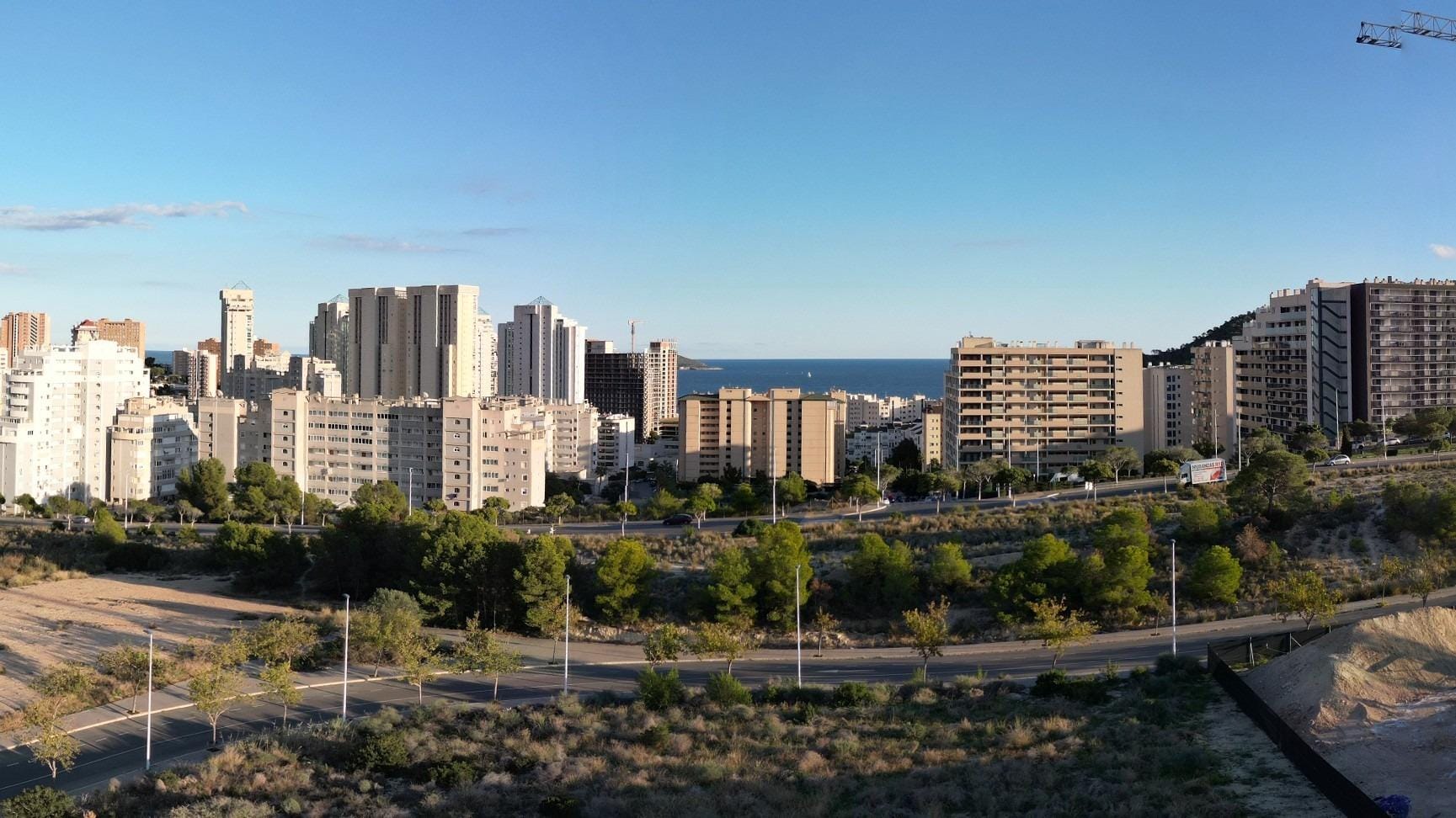 View of high-rise buildings and distant sea from the premium 3 bedroom penthouse with solarium in Cala de Finestrat