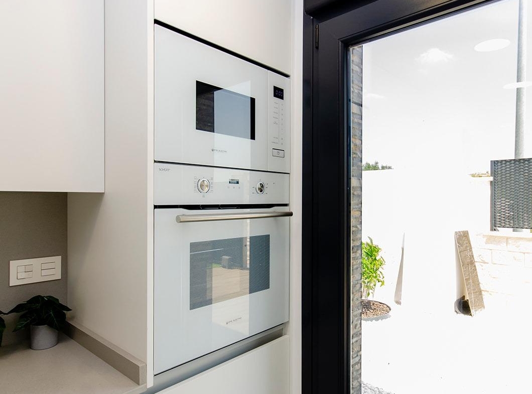 Compact modern kitchen with built-in oven and microwave in stylish new build semi-detached villa at Vistabella Golf Resort