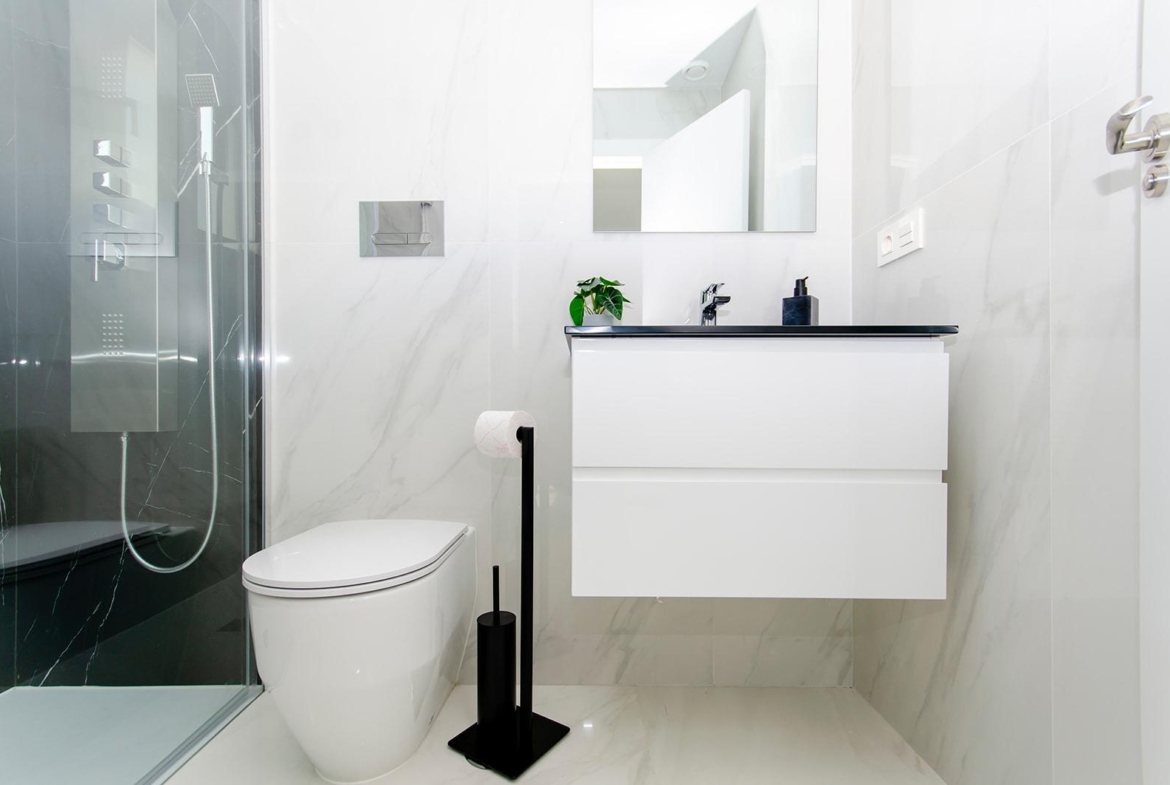 Modern bathroom with glass shower, toilet, and vanity in a new build semi-detached villa at Vistabella Golf Resort