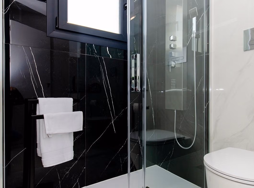 Luxury-New-Build-Semi-Detached-Villas-at-Vistabella-Golf-Resort-31 Modern bathroom with glass shower, black marble wall, and white fixtures in a new build semi-detached villa at Vistabella Golf Resort