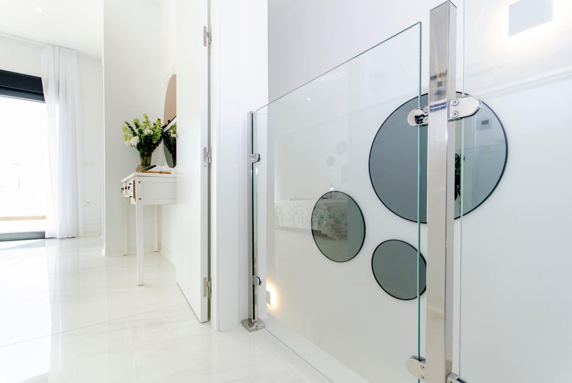 Bright modern interior hallway with glass railing in a stylish new build semi-detached villa at Vistabella Golf Resort