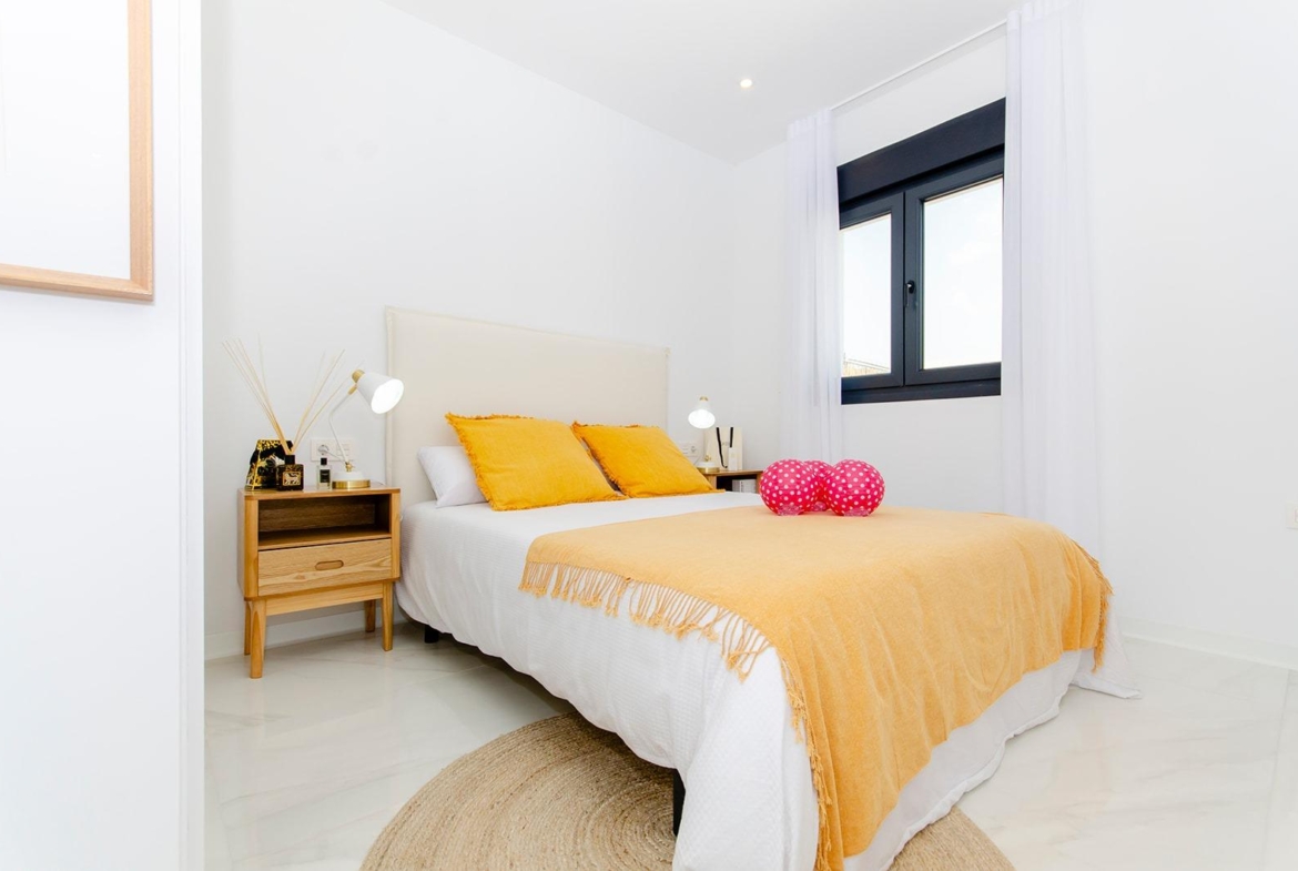 Bright bedroom with double bed and bedside tables in a new build semi-detached villa at Vistabella Golf Resort