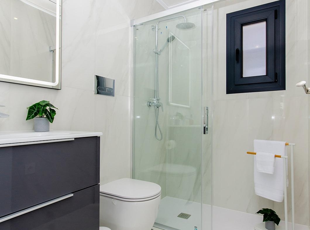 Modern bathroom with glass shower, toilet, and vanity in a semi-detached villa at Vistabella Golf Resort.