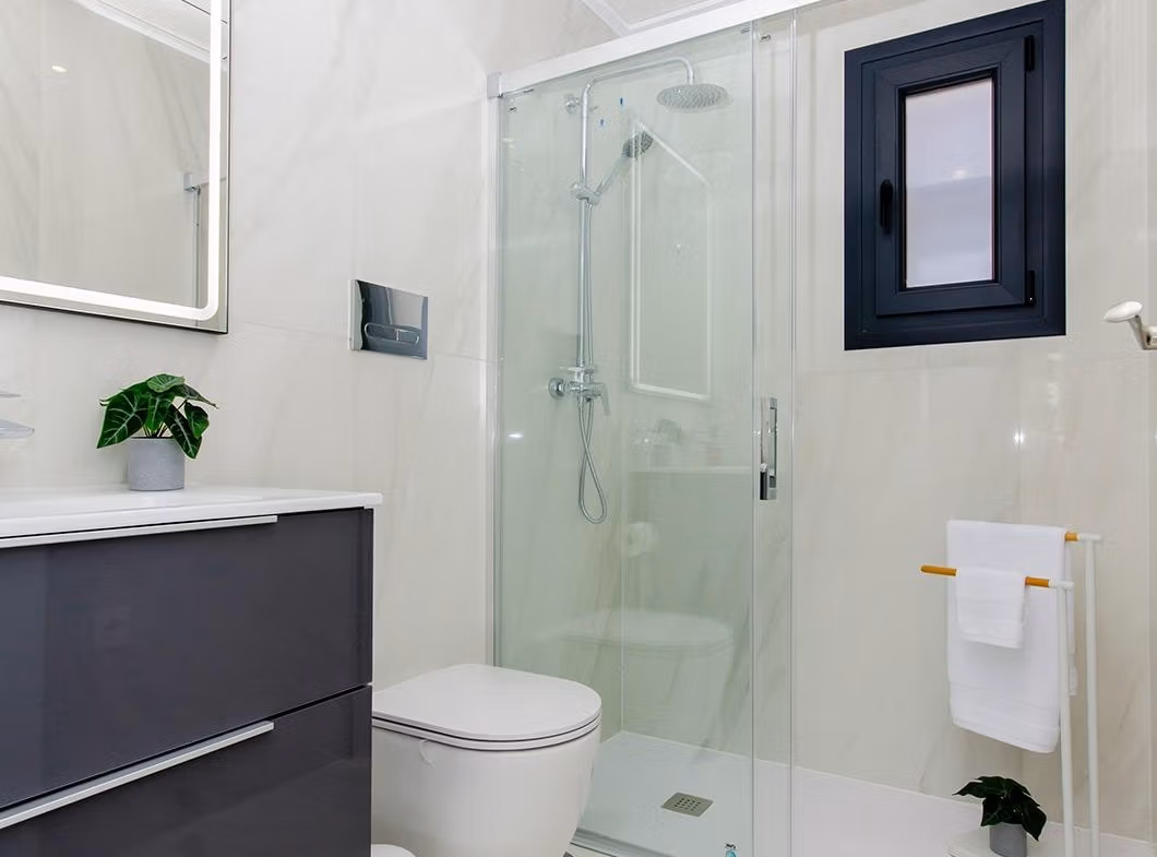 Luxury-New-Build-Semi-Detached-Villas-at-Vistabella-Golf-Resort-38 Modern bathroom with glass shower, toilet, and vanity in a semi-detached villa at Vistabella Golf Resort.