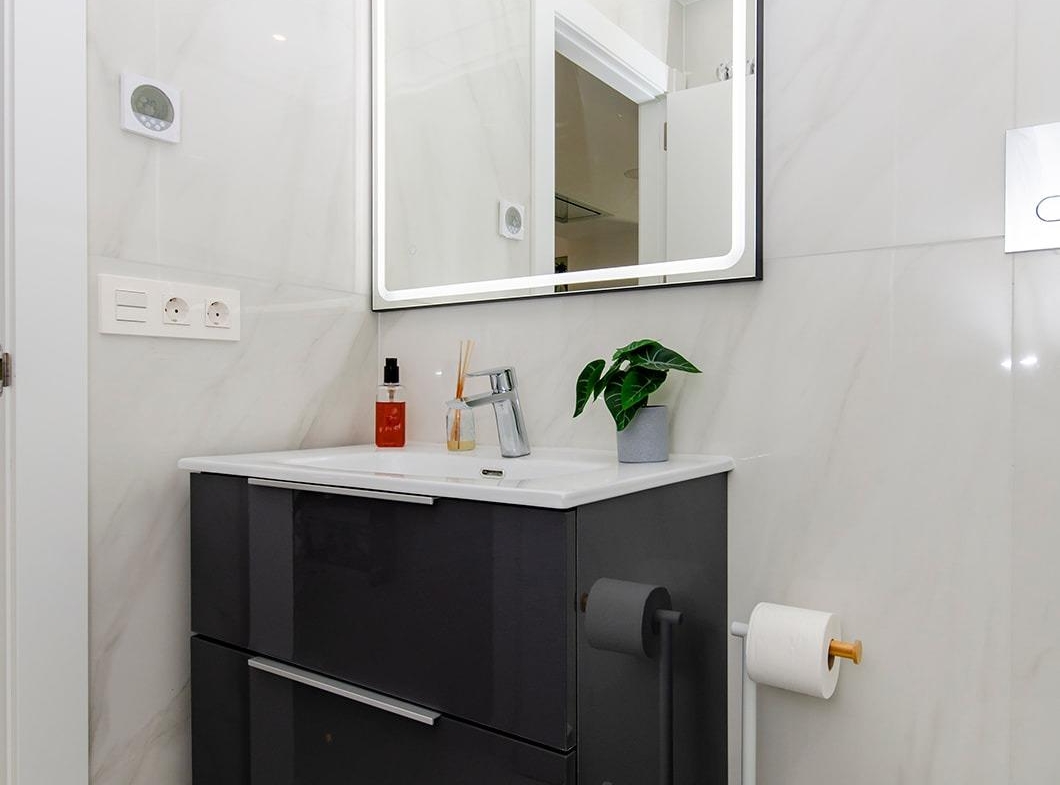 Compact modern bathroom with floating vanity and illuminated mirror in a semi-detached villa at Vistabella Golf Resort