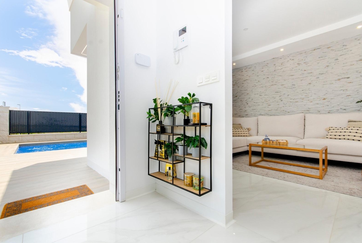 Interior view of a stylish new build semi-detached villa showing the living room and private pool in Vistabella Golf Resort.