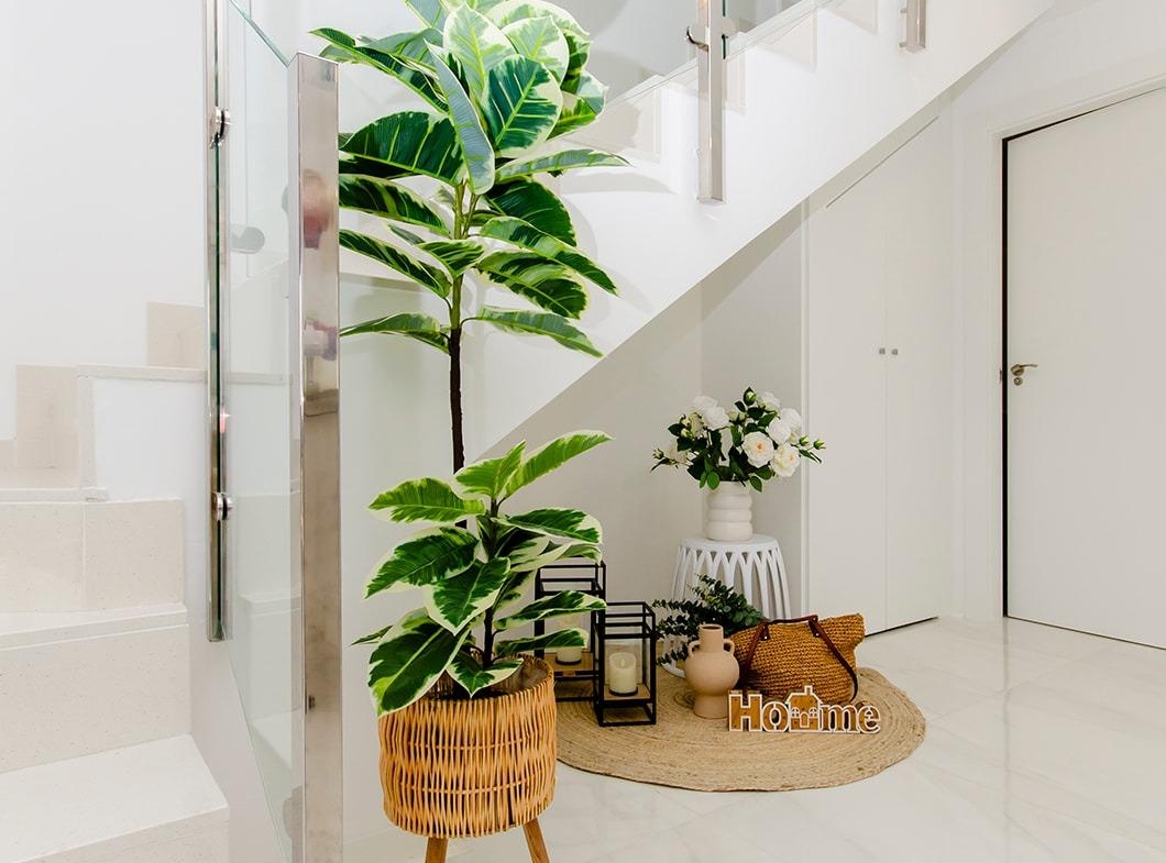 Bright modern hallway with stairs and decorative plants inside a new build semi-detached villa in Vistabella Golf Resort
