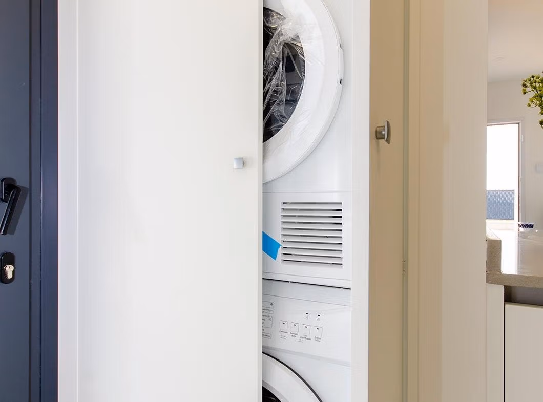 Luxury-New-Build-Semi-Detached-Villas-at-Vistabella-Golf-Resort-45 Laundry area with stacked washer and dryer inside a stylish new build semi-detached villa in Vistabella Golf Resort.