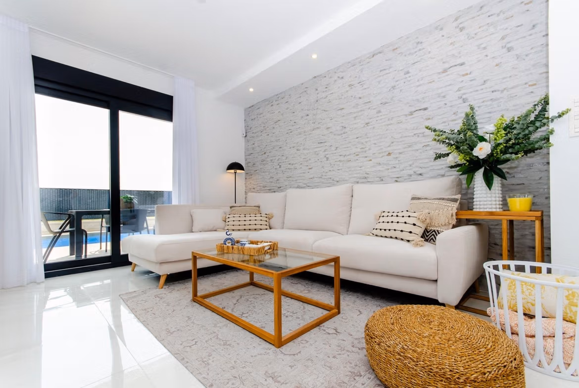 Luxury-New-Build-Semi-Detached-Villas-at-Vistabella-Golf-Resort-5 Bright living room with white sofa and glass doors opening to pool in a new semi-detached villa at Vistabella Golf Resort