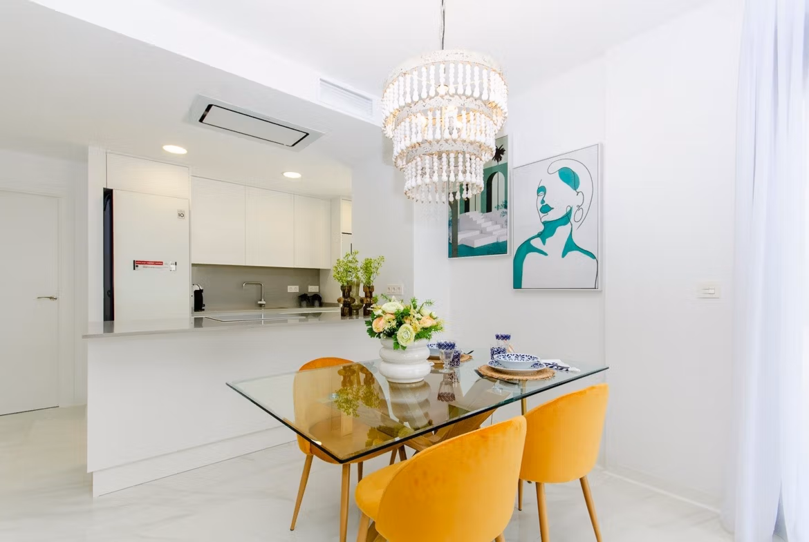 Luxury-New-Build-Semi-Detached-Villas-at-Vistabella-Golf-Resort-9 Bright dining area with glass table and yellow chairs next to a modern kitchen in a new build semi-detached villa at Vistabella Golf Resort
