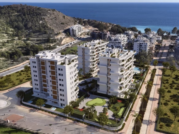 Modern white apartment buildings with landscaped gardens and sea view in a luxury resort near the beach in Villajoyosa.