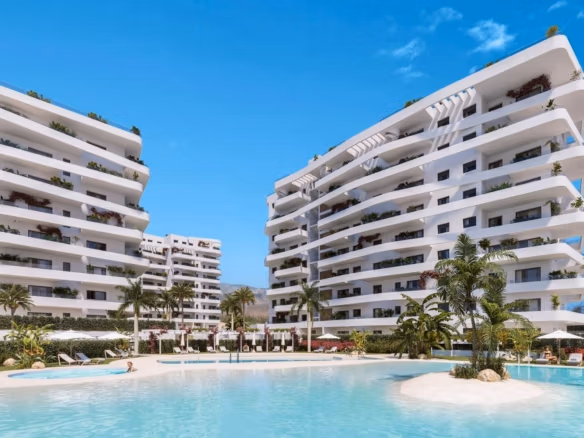 White modern elevated apartment buildings with balconies and pool area in luxury resort near Villajoyosa beach