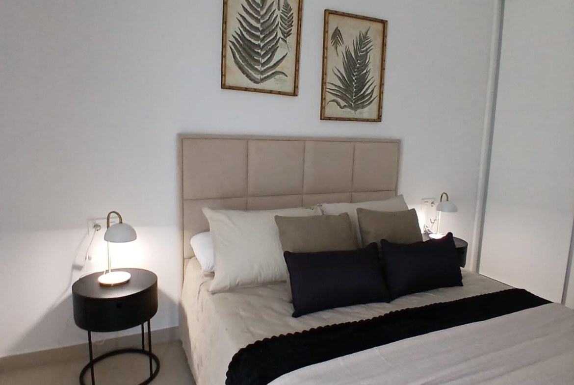 Modern bedroom with neutral bedding and bedside tables in a new build quad property in Bigastro, Alicante.
