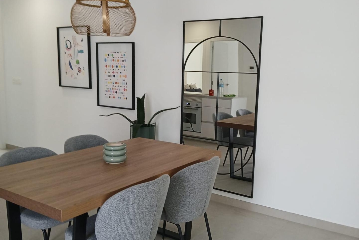 Dining area with wooden table and chairs in a new build quad villa in Bigastro, Alicante