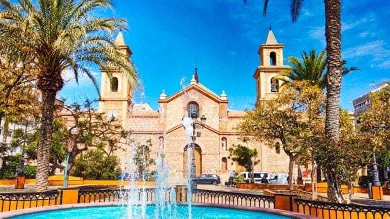 Fountain and palm trees in a sunny square near a church in Torrevieja, close to the new build 1 bedroom penthouse.