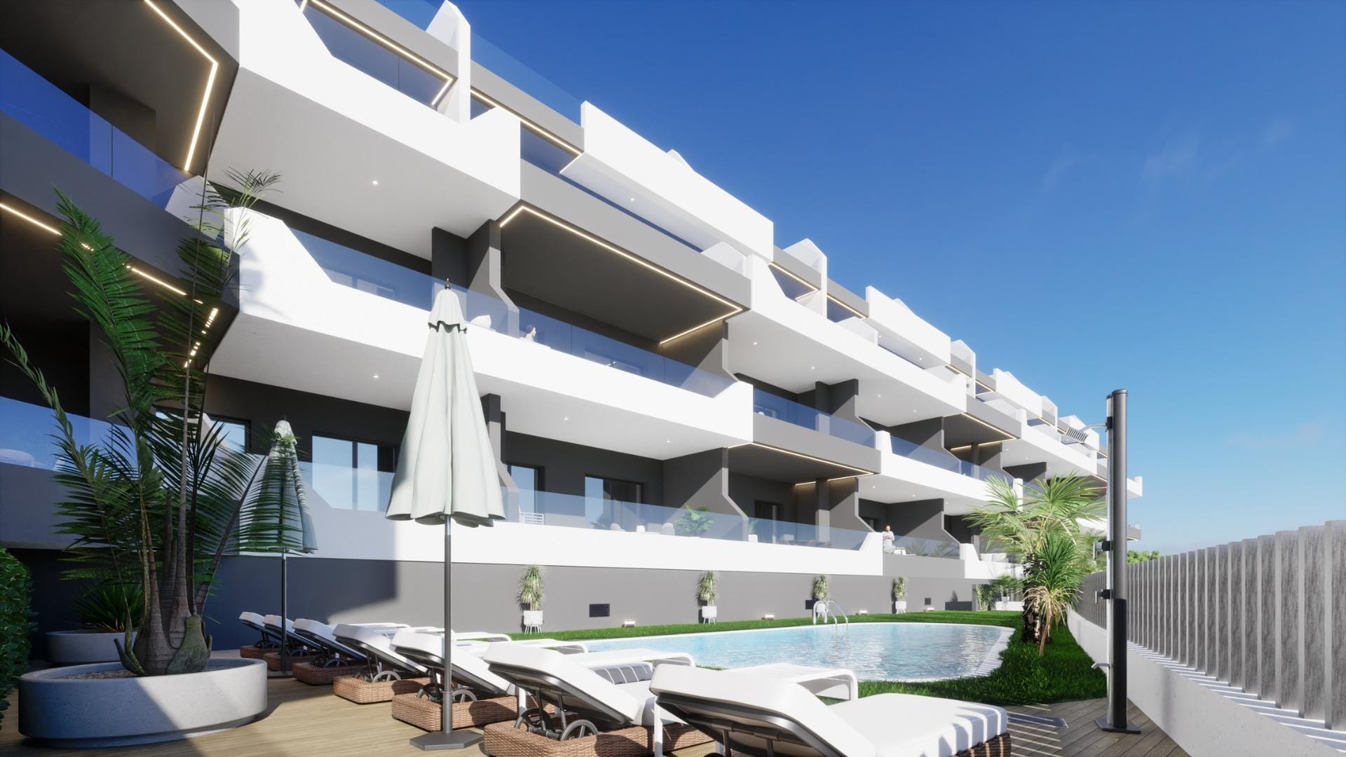 Modern new build 4 bedroom apartment in Benijofar Alicante with outdoor pool, sun loungers, and large balconies under clear blue sky.