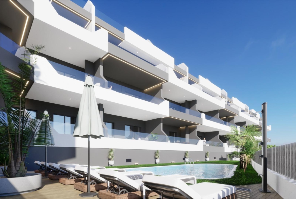 Exterior view of new build 3 bedroom ground floor apartment in Benijofar with pool and sun loungers under clear sky