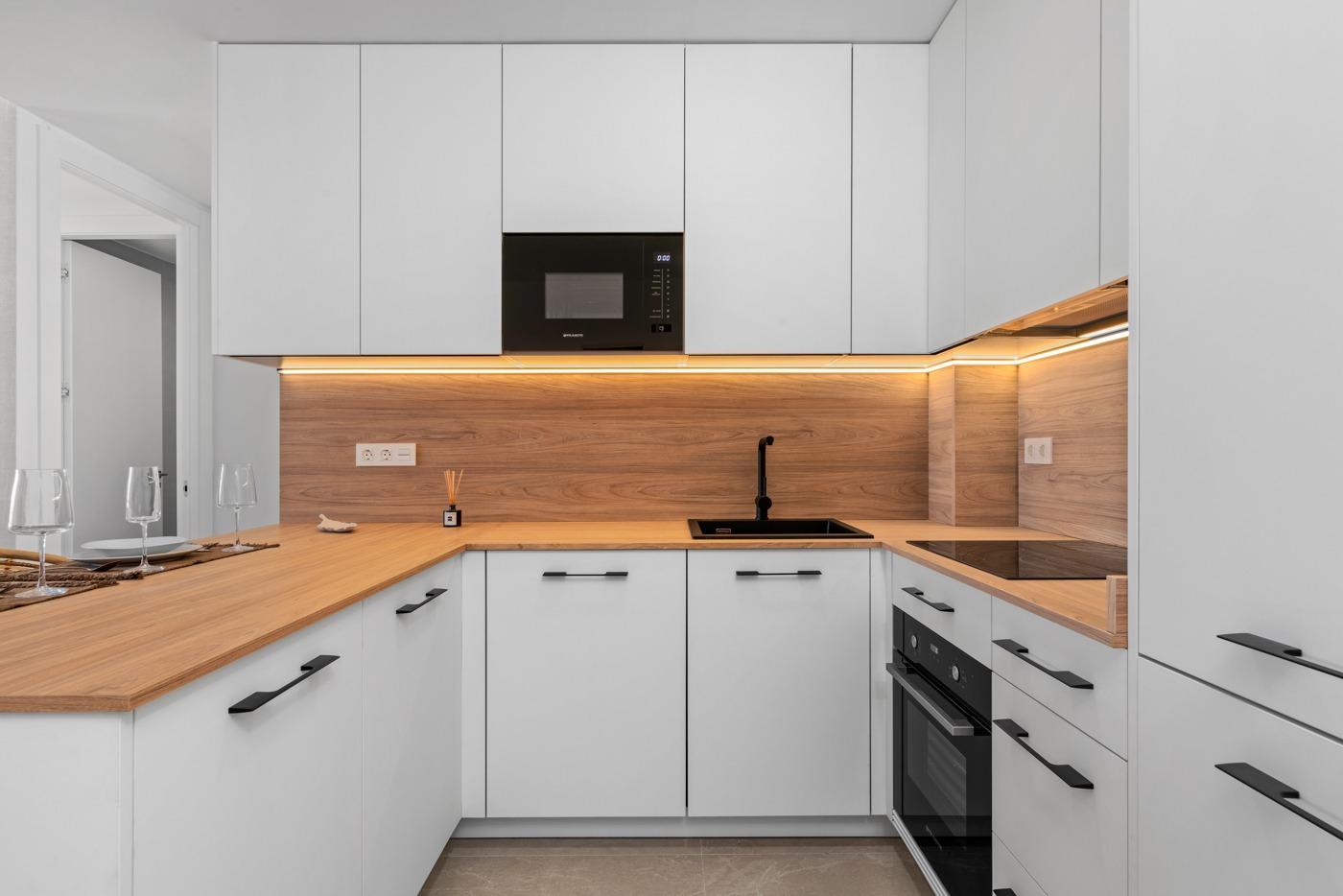 Modern kitchen with white cabinets and wooden countertops in a 2 bedroom ground floor apartment in Benijofar