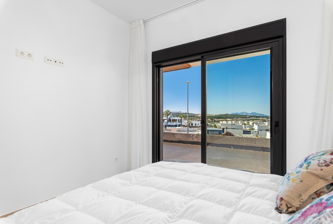 Bright bedroom with sliding glass doors opening to a terrace in a new build 4-bedroom ground floor apartment in Benijofar.