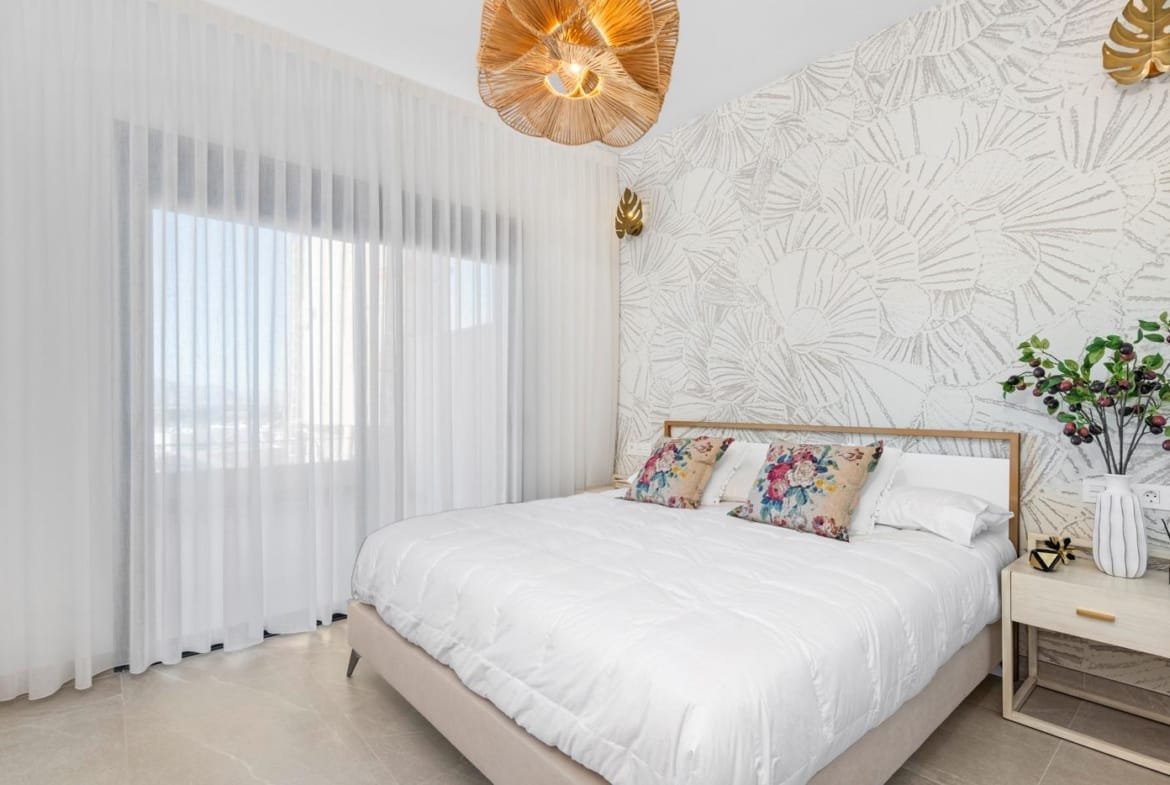 Bright bedroom with double bed and decorative wall in spacious new build 4 bedroom apartment in Benijofar, Alicante