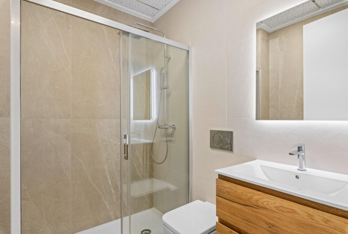 Modern bathroom with glass shower and wooden vanity in a 2 bedroom ground floor apartment in Benijofar.
