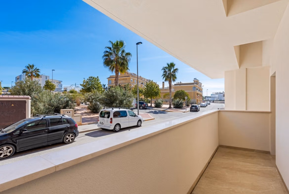 Balcony view from a new build 2 bedroom apartment overlooking a quiet street with palm trees in Benijofar, Alicante