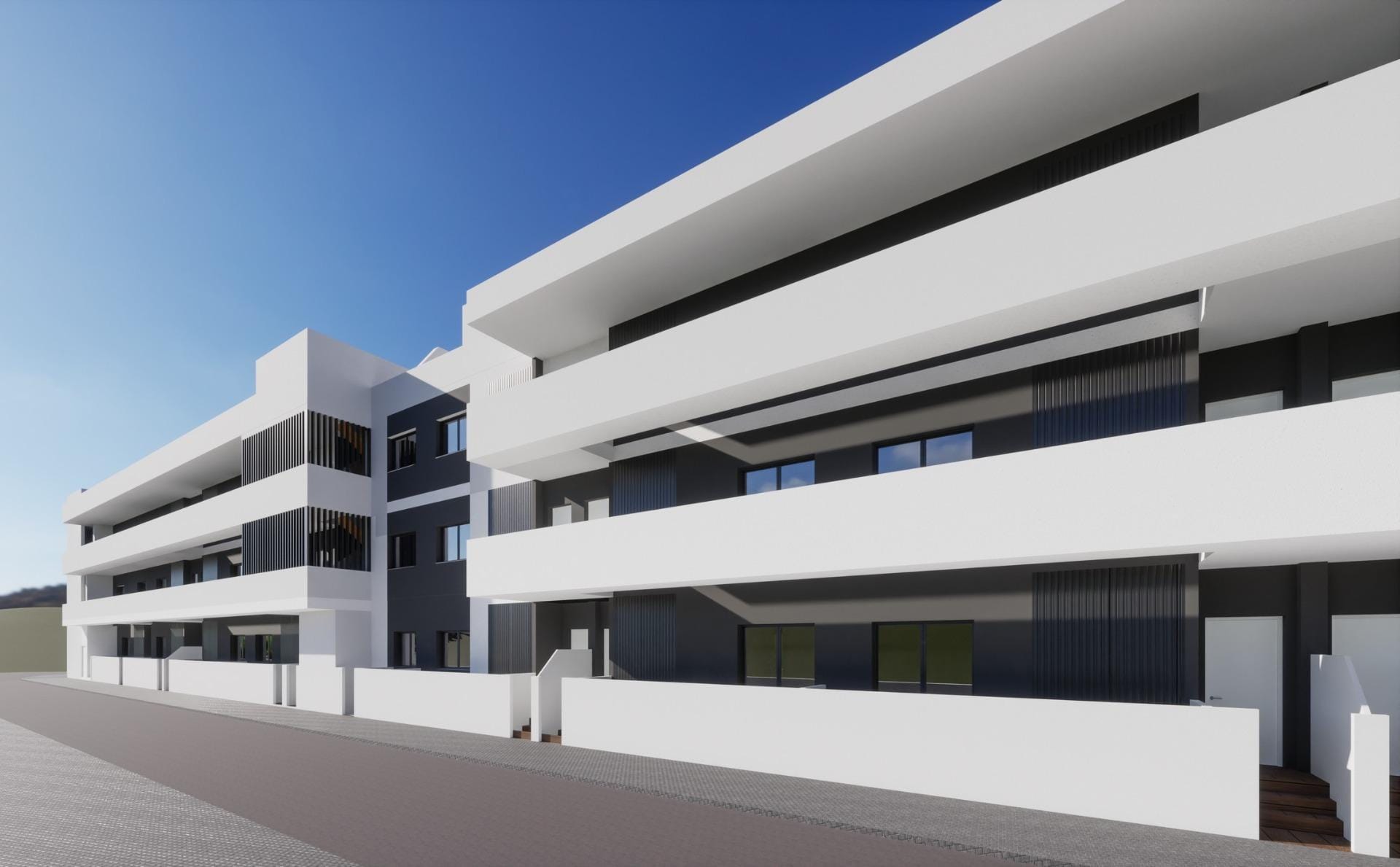 Modern white exterior of a new build 2 bedroom ground floor apartment building in Benijofar under clear blue sky