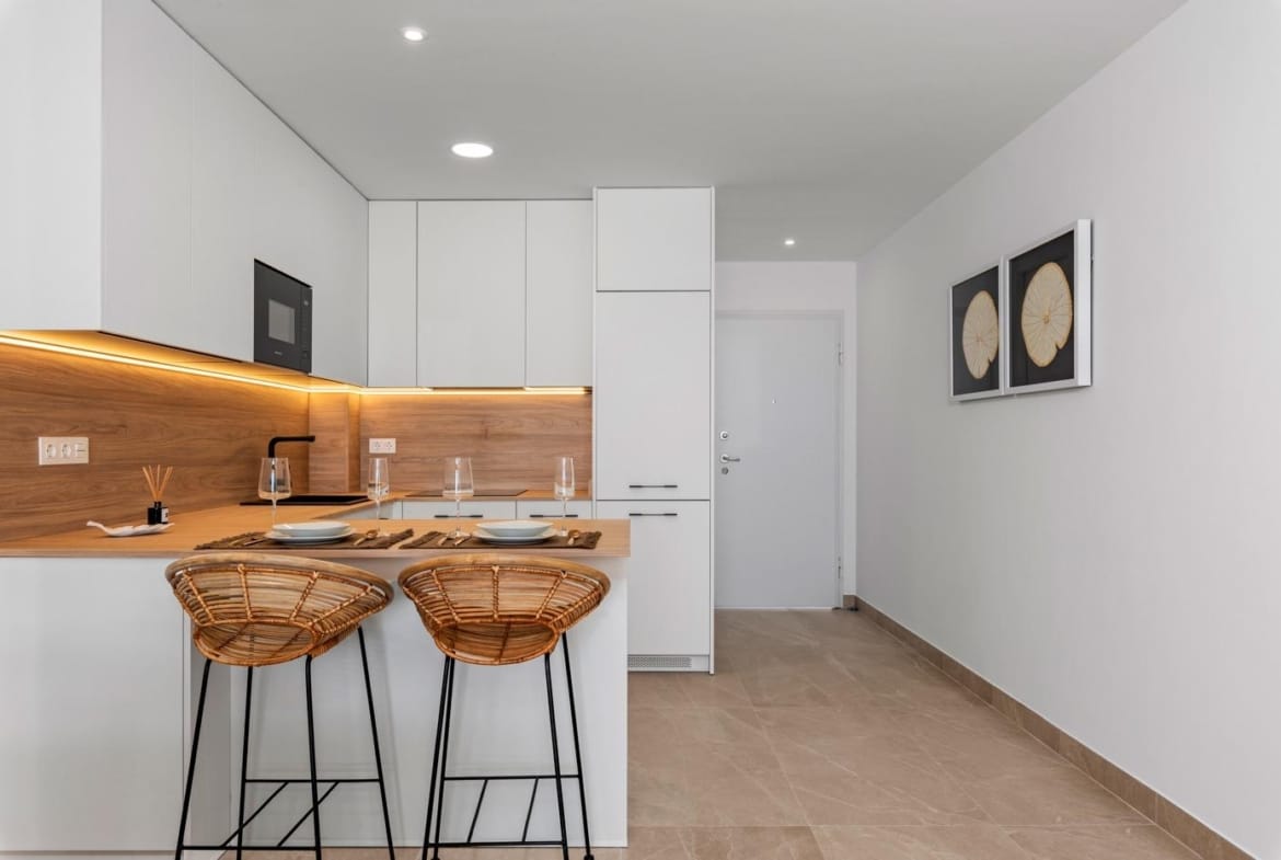 Modern kitchen with breakfast bar and stools in a spacious new build 4 bedroom apartment in Benijofar, Alicante