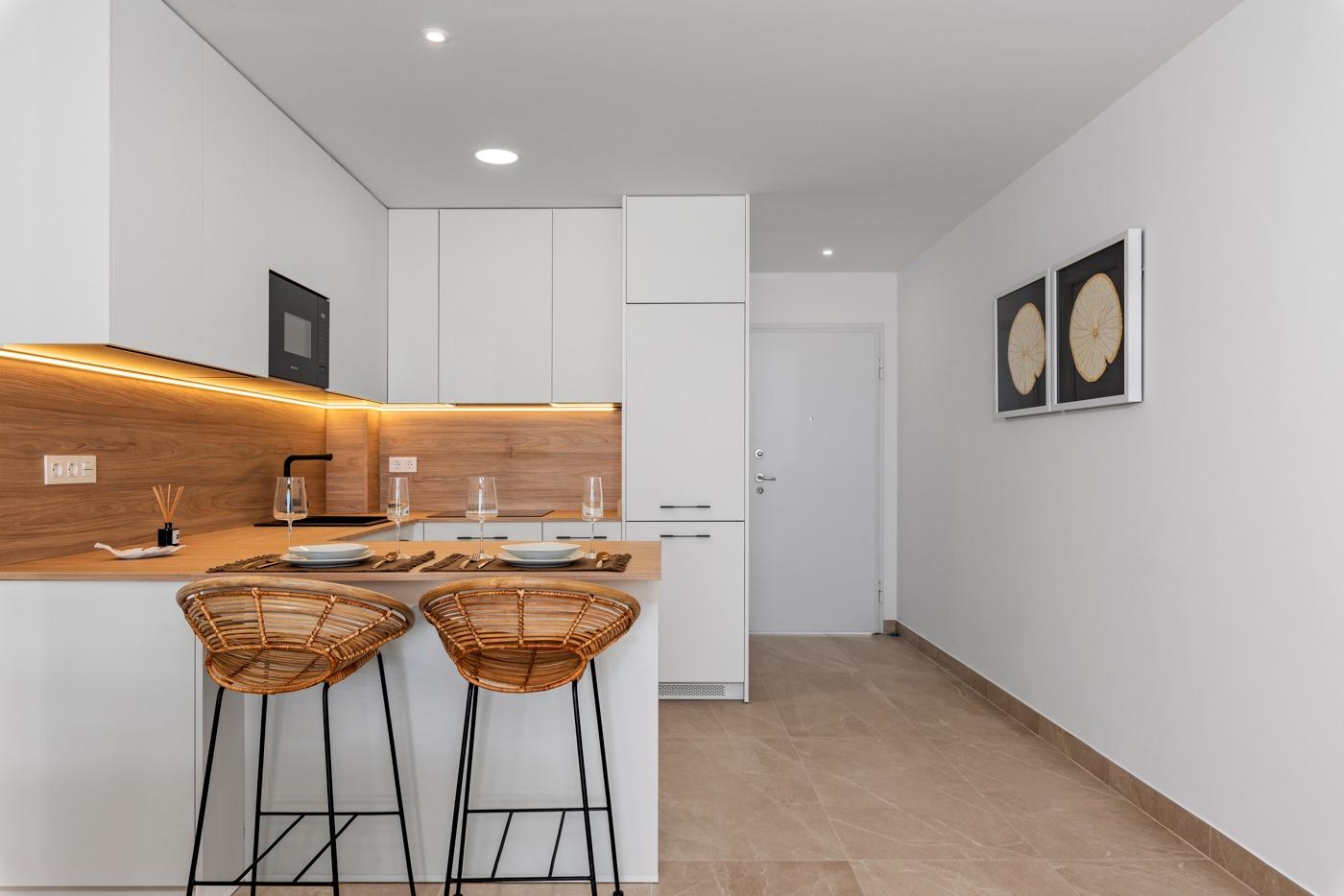 Modern kitchen with breakfast bar and stools in a new build 3 bedroom ground floor apartment in Benijofar