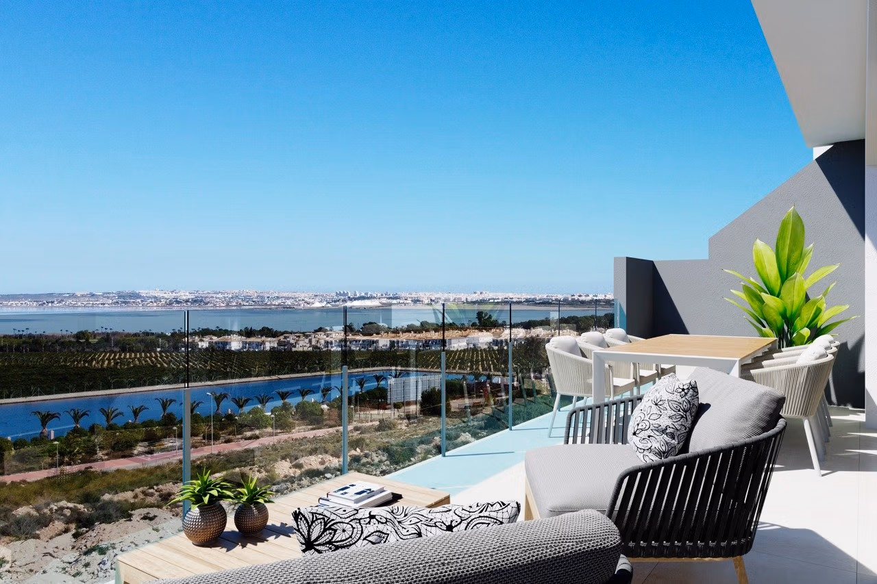 TORREVIEJA Top floor apartment terrace with seating and dining area overlooking sea and coastline in Los Balcones, Torrevieja.