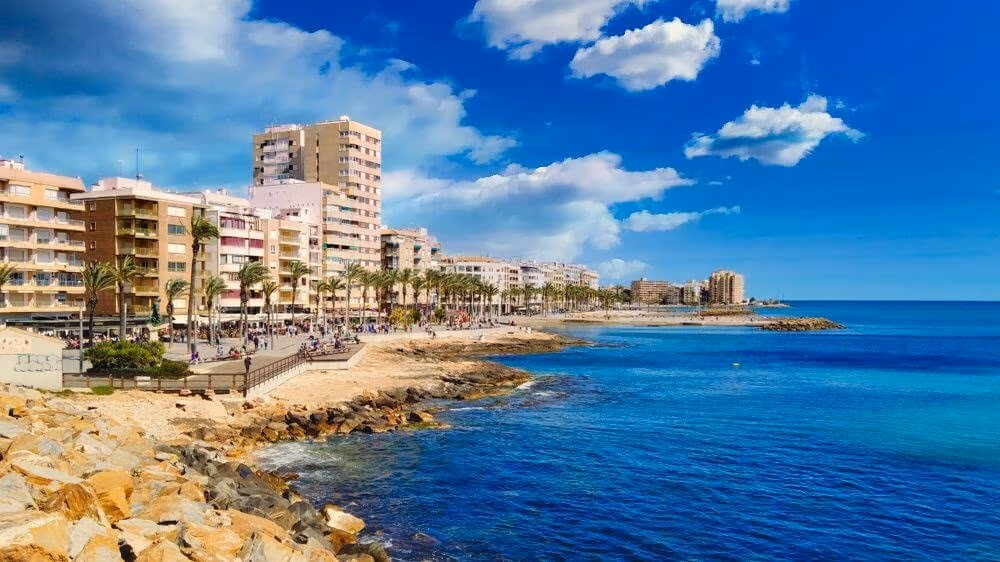 NEW-BUILD-RESIDENCIAL-IN-LOS-BALCONES-TORREVIEJA-16 Oceanfront view of the coastline near Los Balcones, Torrevieja, showcasing the seaside and nearby residential buildings.