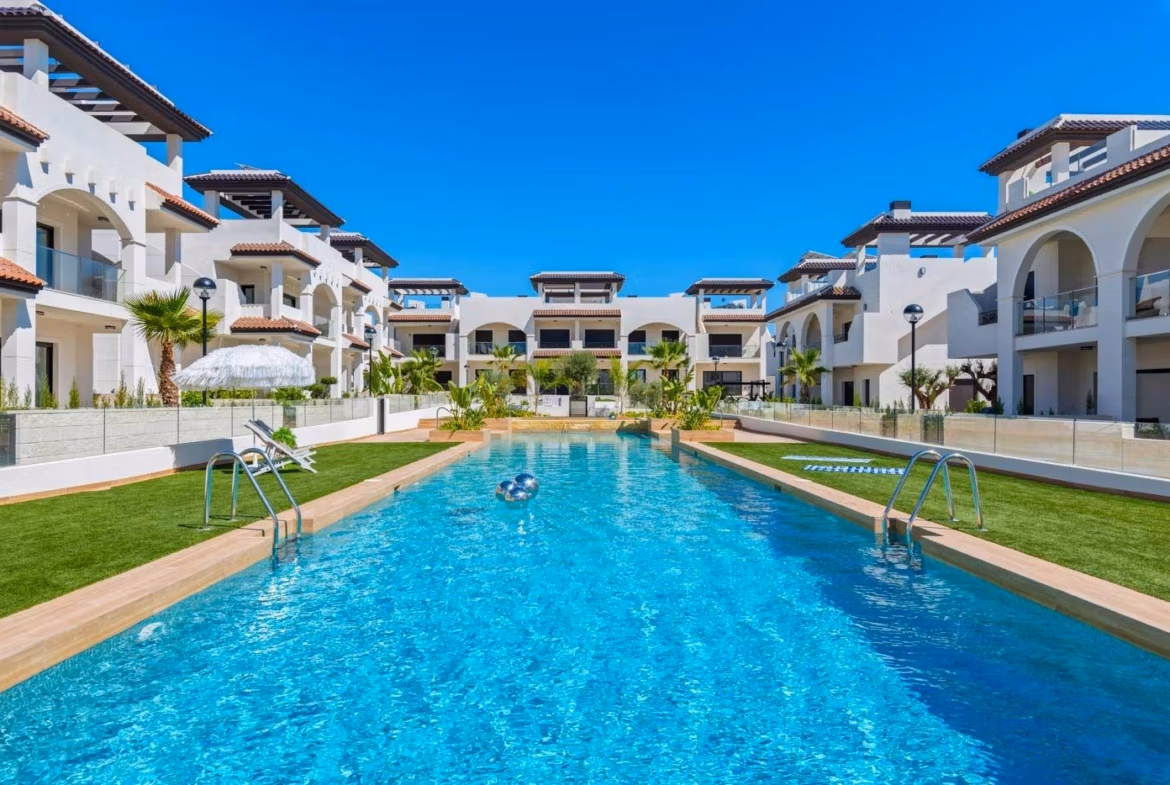 NEW-BUILD-RESIDENTIAL-COMPLEX-IN-ROJALES-9 Outdoor swimming pool surrounded by modern penthouse apartments with solariums in Rojales new build complex.