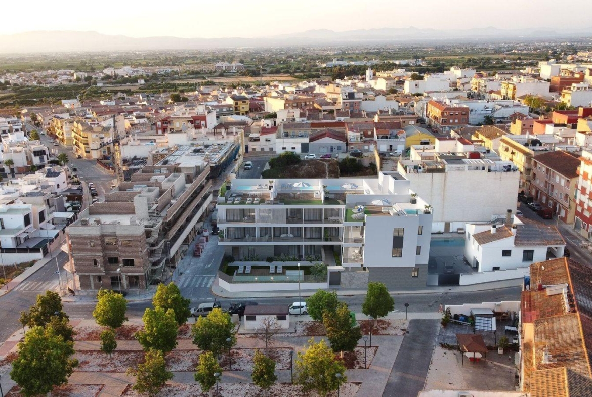 Aerial view of a modern new build 3 bedroom apartment in Benijofar with communal pool and surrounding townscape.