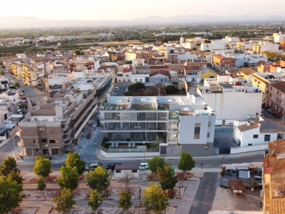 Aerial view of obra nueva apartamento complex con communal piscina y surrounding town en Benijofar, Costa Blanca.