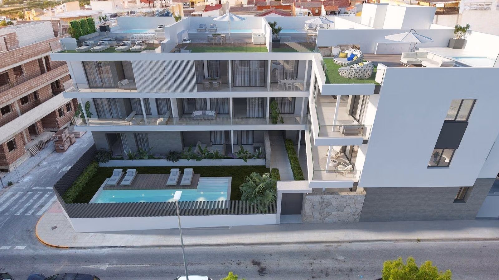 Communal pool and sun loungers in front of modern new build 3 bedroom apartment in Benijofar with rooftop terrace.